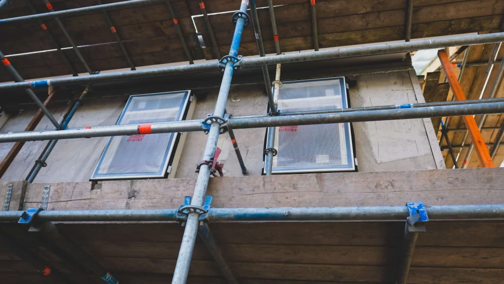 Scaffolding on a building with windows and doors. Representing HOA reserve studies