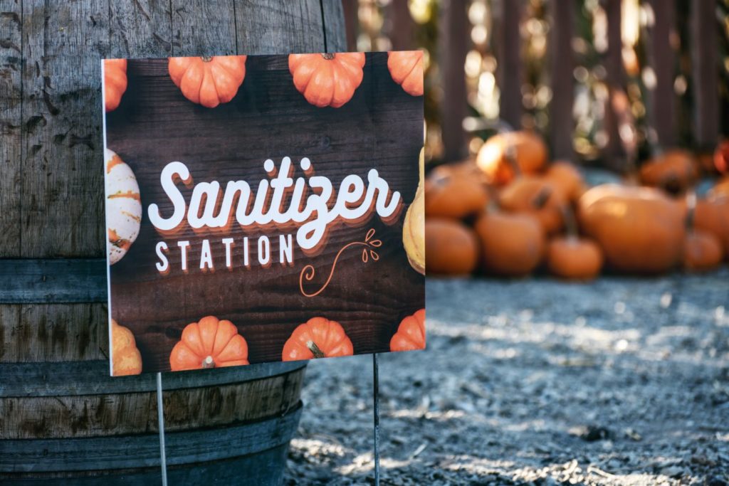 halloween covid 19 - image of pumpkins and a sanitizer station sign