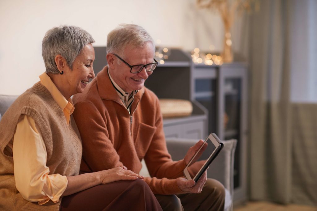 engage hoa residents software - image of an grey haired woman with a balding man holding a tablet