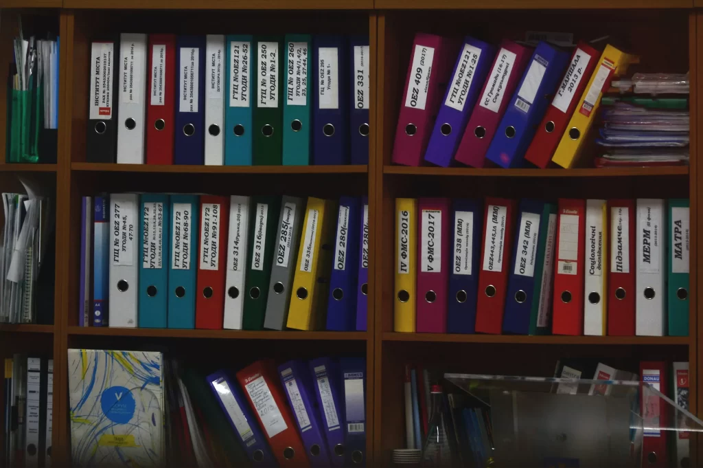 3 shelves full of colorful folders representing HOA records