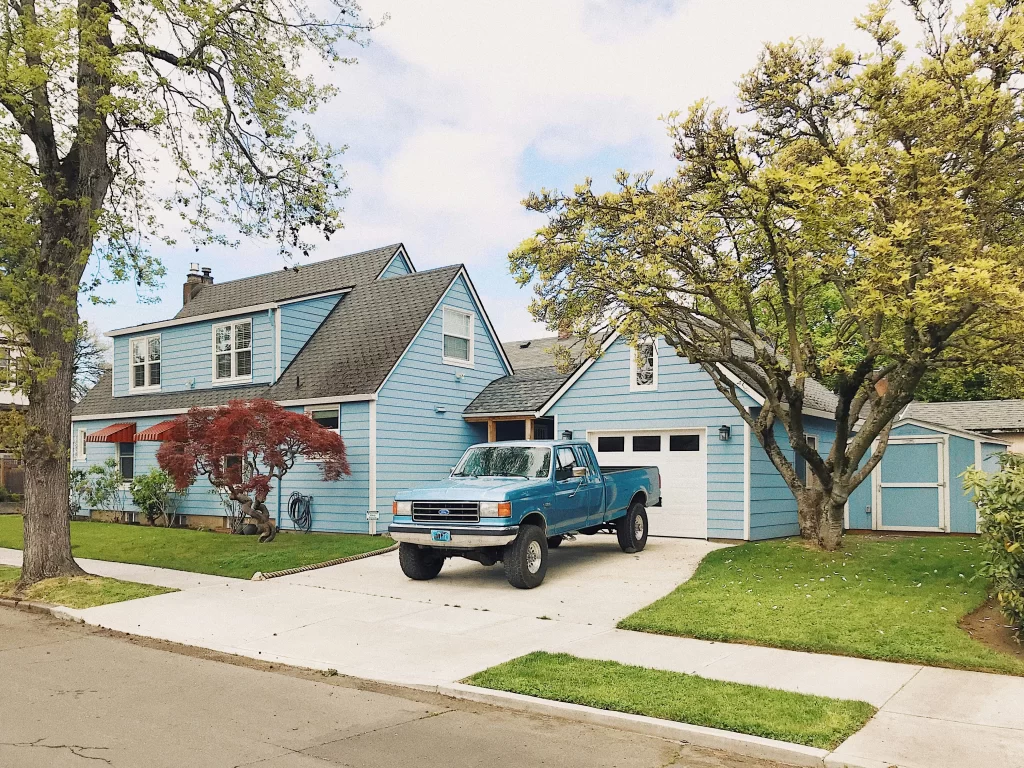 HOA Parking problem represented by a blue truck parked in front of a garage