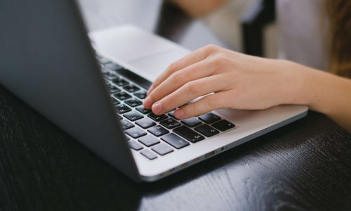 HOA Communication Tools: Person typing on laptop