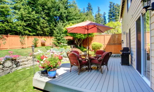 HOA backyard rules: Image of a tidy backyard with trimmed grass, flower beds, and a patio