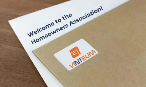 An HOA welcome letter, written: welcome to the homeowners association and an envelope from Vinteum