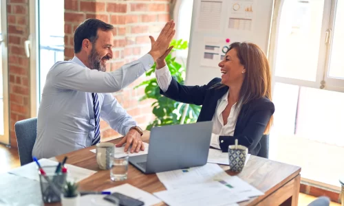 Two professionals enthusiastically high-fiving, symbolizing successful HOA management companies in Houston, Texas.