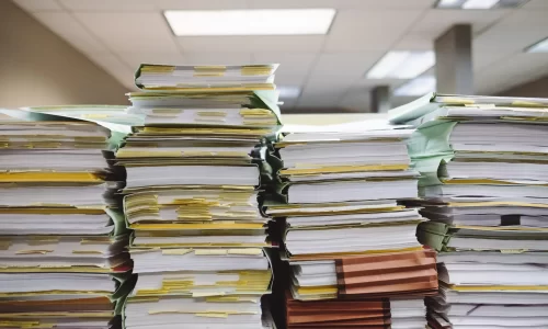 4 piles of folders full of documents representing HOA records