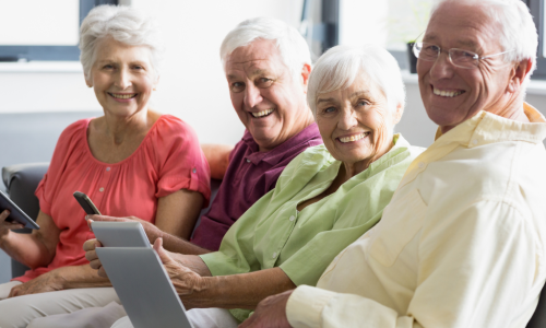 Four board members delightedly using self-managed condo association software on mobile phones and laptop for efficient community management